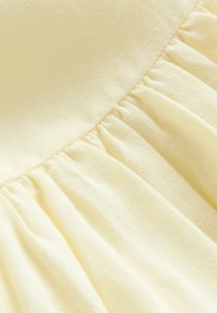 Tissu jaune avec une texture froncée, surface lisse et matériau léger, idéal pour les vêtements ou les accessoires.