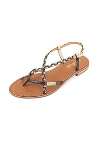 Sandale noire et dorée à lanières avec une semelle plate, présentant des accents tressés et une semelle intérieure beige. Design à bout ouvert avec une bride à la cheville ajustable.