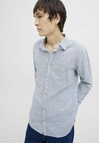 Camisa de botones a rayas en algodón azul claro y blanco. Presenta un cuello, mangas largas y un dobladillo curvado con pequeños botones redondos.