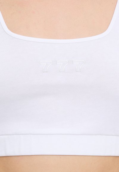 Hvit crop topp med firkantet hals og myk tekstur. Et bemerkelsesverdig detalj er de broderte tallene "777" på forsiden.
