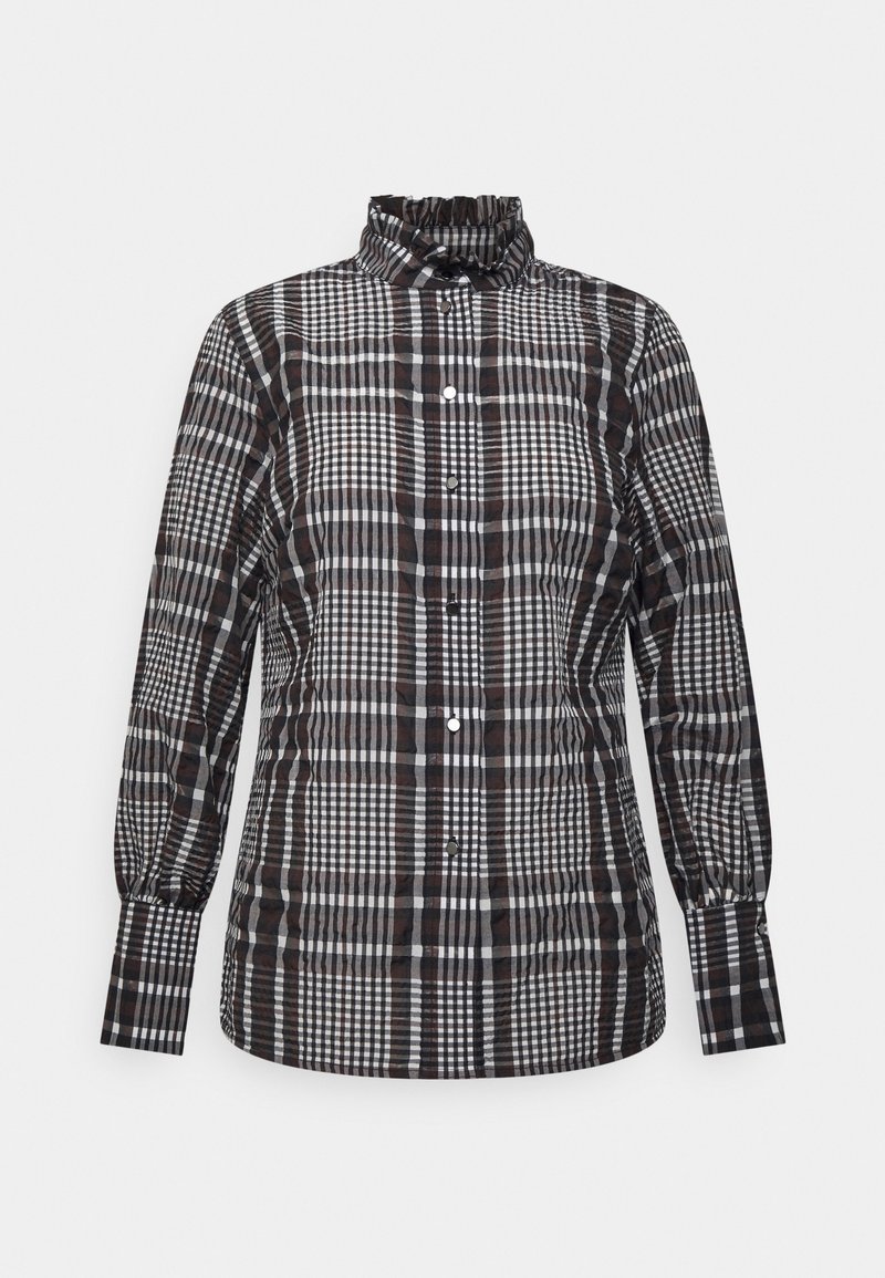Chemise à manches longues à carreaux noirs, blancs et marron avec col haut volanté et fermeture boutonnée sur fond uni.