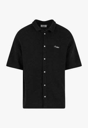 Camisa negra de mangas cortas con botones, fabricada en material acanalado, con cuello puntiagudo y logotipo bordado en el lado izquierdo del pecho.