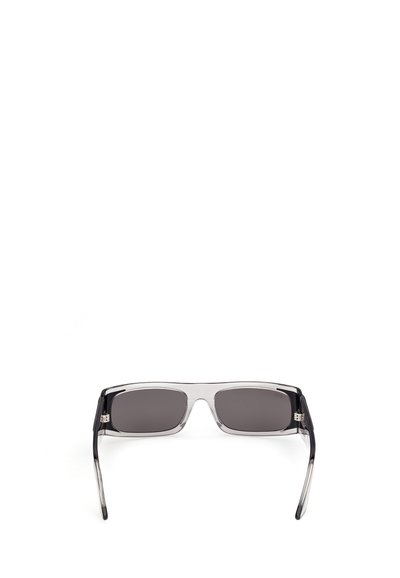 Gafas de sol rectangulares con lentes tintadas negras y montura transparente negra, vistas desde el frente sobre un fondo blanco.