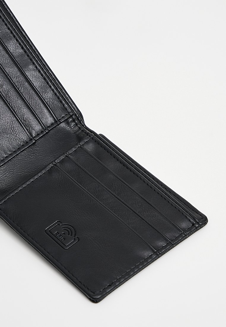 Interno di un portafoglio in pelle nera con scomparti per carte, texture liscia e dettagli con logo. Presenta numerosi scomparti per carte per una migliore organizzazione.
