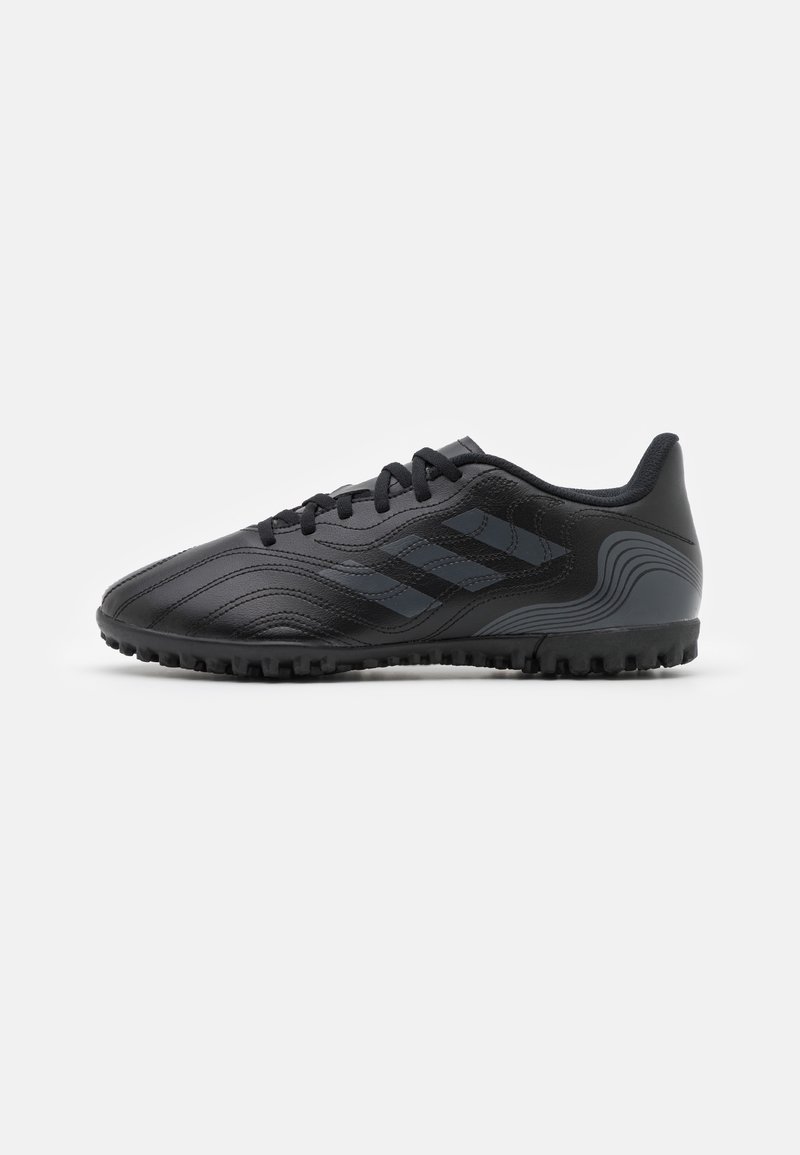 Chaussures de football noires avec dessus synthétique texturé, présentant des bandes ton sur ton et une semelle en caoutchouc crantée pour la traction. Design basique à lacets.