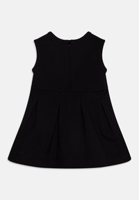 Czarna sukienka bez rękawów z plisowanym dołem, okrągłym dekoltem i zapięciem na zamek z tyłu. Wykonana z miękkiego, teksturowanego materiału.