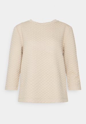 Kremowy, długi rękaw sweter o fakturowanym splocie z subtelnym wzorem jodełki i okrągłym dekoltem, prezentowany na jednolitym tle.