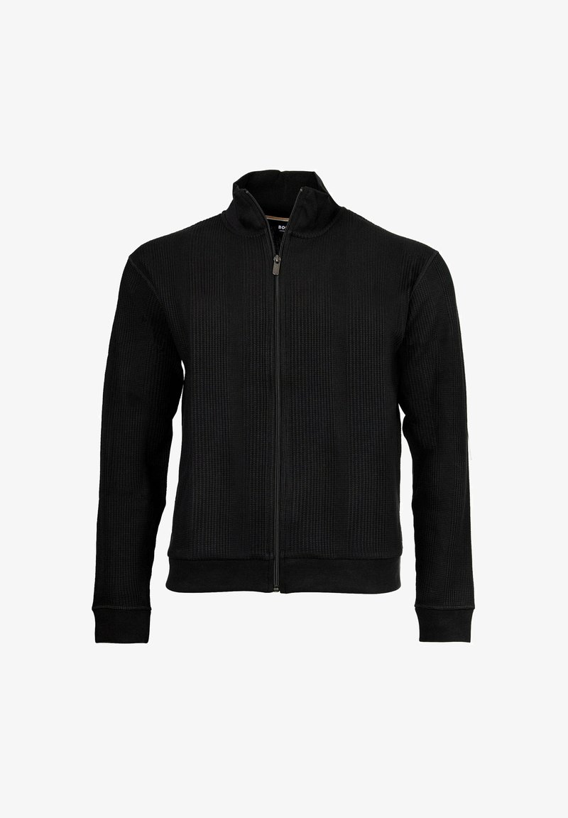 Giacca nera con cerniera frontale, texture a coste, colletto alto e maniche lunghe. Presenta una zip lunga e una vita aderente.
