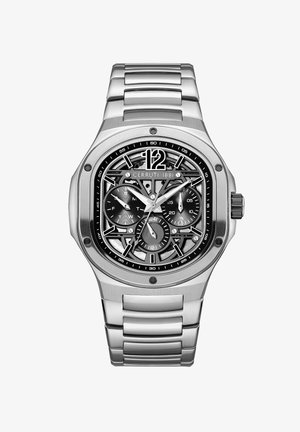 Reloj de acero inoxidable plateado con un dial esqueleto, acentos negros y funciones de cronógrafo. Caja octagonal y diseño de pulsera articulada.