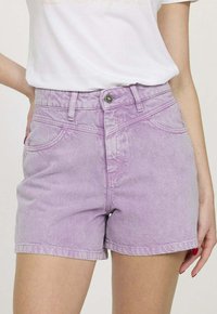 Shorts en denim violet à taille haute et poches avant ; dotés d'un boutonnière classique et d'une texture légèrement déchirée.