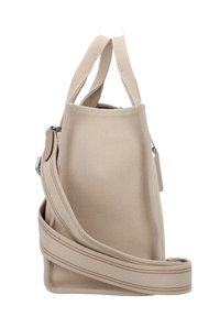Beige canvas handbag with dual handles and an adjustable shoulder strap. Features a textured surface and a side zipper pocket.