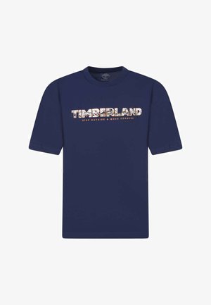 T-shirt en coton bleu marine avec le mot "TIMBERLAND" en lettres décorées et la phrase "SORTEZ ET AVANCEZ" en dessous.
