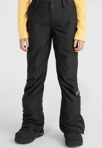 Zwarte sneeuwbroek met een losse pasvorm, waterdicht materiaal, versterkte knieën, ritszakken en een klein logopatch aan de zijkant.