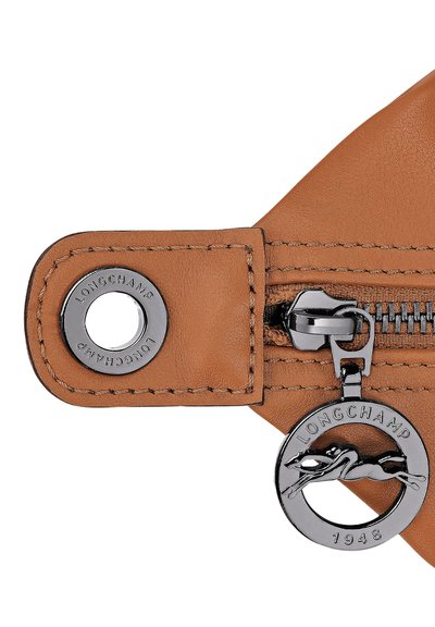 Braune Lederetui mit Reißverschluss, das eine silberne Logo-Medaille und polierte Reißverschlussteile mit kontrastierenden Steppnähten aufweist.