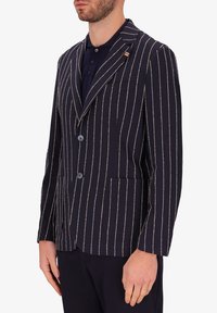 Blazer a righe navy con linee bianche e beige, design monopetto, due tasche frontali e dettagli dei bottoni a contrasto.