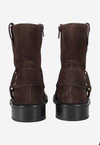 Bottines en suede marron avec une finition texturée, dotées d'une fermeture éclair sur le côté et de détails en sangle. Semelles épaisses en caoutchouc noir pour plus de durabilité.