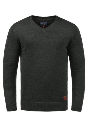 Dunkelgrüner V-Ausschnitt-Pullover aus strukturiertem Strickstoff, mit langen Ärmeln und einem kleinen braunen Lederlogo-Patch am Saum.