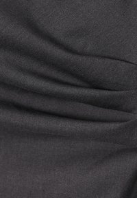 Tissu noir texturé montrant de fines lignes diagonales et des plis, avec une surface lisse et un léger éclat subtil.