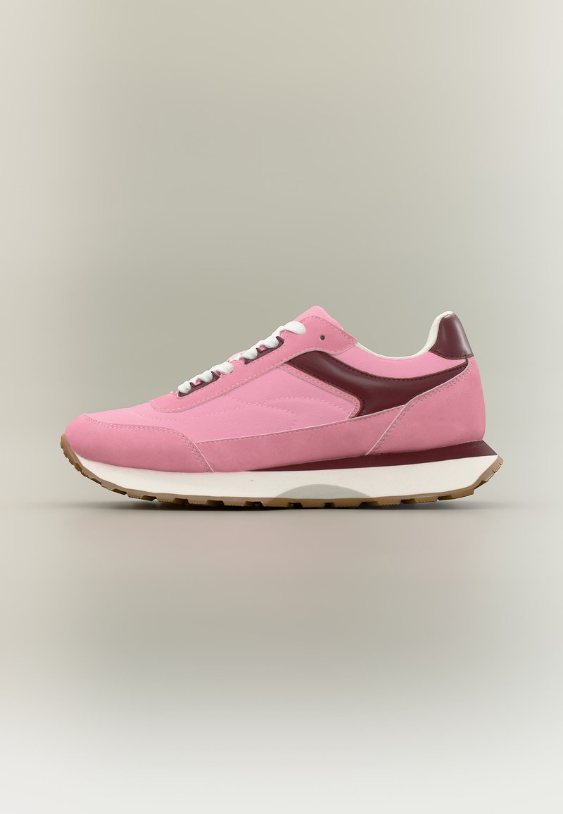 Ροζ και σκουρόκοκκινο αθλητικό παπούτσι χαμηλού ύψους με λευκά κορδόνια, παχύ λευκό πέλμα και ταμπά λαστιχένια σόλα σε ουδέτερο φόντο.