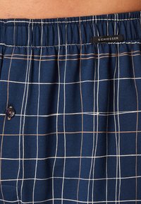 Boxer navy blu in cotone morbido, con un motivo a griglia bianco e beige, cintura elastica e una piccola etichetta del marchio cucita.