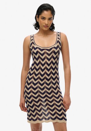 Vævet kjole med et zigzag-mønster i navy og beige, med skulderstropper og en knælængde. Teksturdesign i strik.