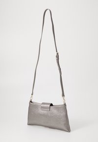 Small silver metallic shoulder bag with adjustable strap and flap closure, displayed against a plain light background.