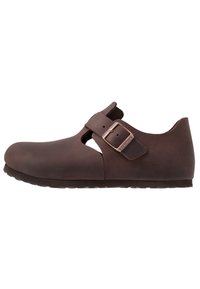 Brown leather clog with an open side, single strap featuring a metal buckle, and a thick, textured rubber sole.