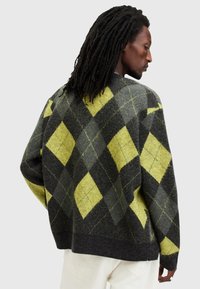 Maglione a maglia con un motivo argyle nero e giallo, forma boxy, colletto e orlo a coste, realizzato in un morbido misto lana testurizzato.