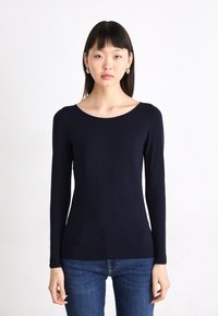 Mouwen lange navy top van zachte stof met een brede halslijn, getailleerde pasvorm en minimalistisch ontwerp, gecombineerd met spijkerbroek.