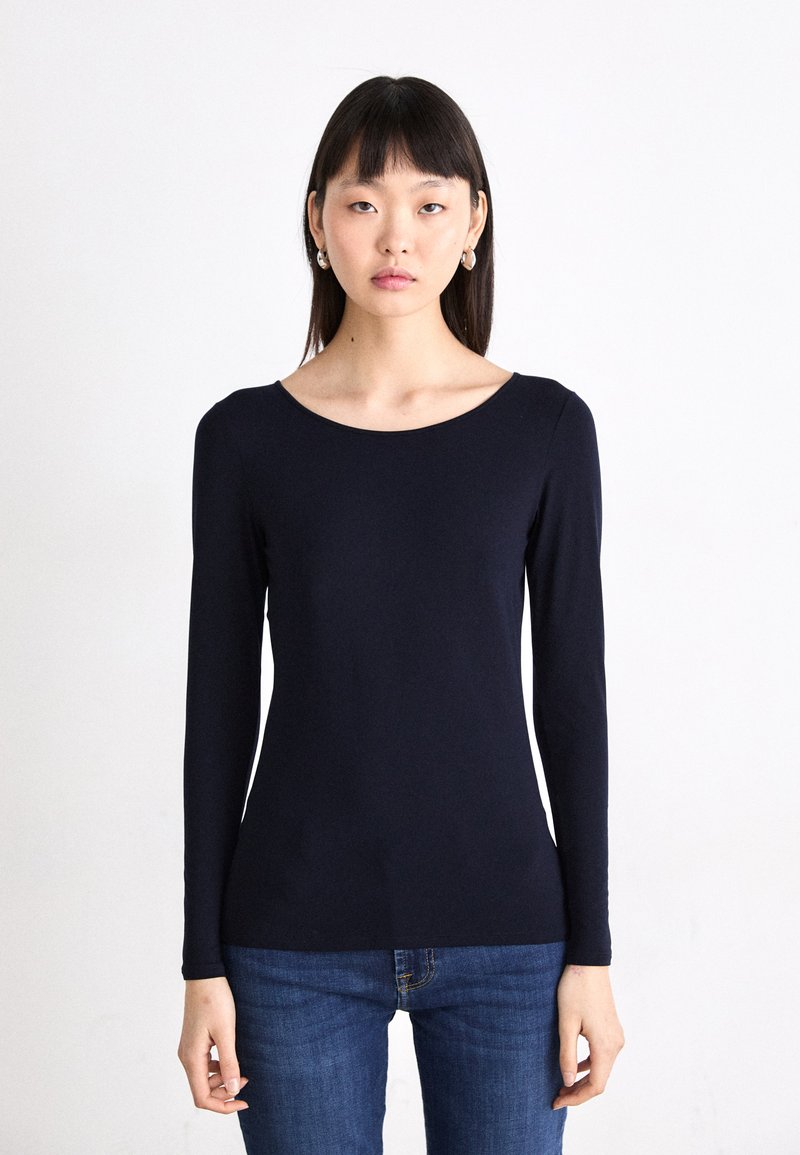 Mouwen lange navy top van zachte stof met een brede halslijn, getailleerde pasvorm en minimalistisch ontwerp, gecombineerd met spijkerbroek.