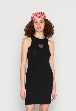 Vestido preto sem mangas com um recorte em forma de coração transparente no peito. O tecido é suave e possui uma silhueta ajustada.