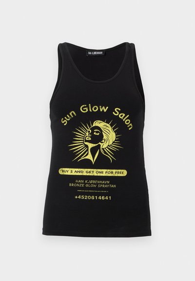 Mustast tanktopist naise näo kollase graafikaga, mille ümber on päikesekiired, tekst "Sun Glow Salon", reklaampakkumine ja kontakttelefoninumber.