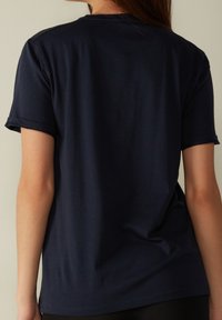 Mørkeblå t-shirt i blødt stof med en afslappet pasform. Korte ærmer, rund halsudskæring og synlige sømdetaljer.