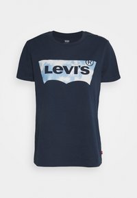 Námorně modré bavlněné tričko s velkým světle modrým logem Levi's na přední straně. Krátké rukávy a kulatý výstřih dotvářejí design.