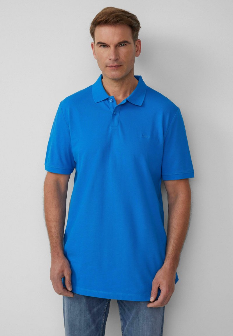 Niebieska koszulka polo z klasycznym kołnierzykiem, krótkimi rękawami i subtelnym logo na piersi, wykonana z gładkiego materiału bawełnianego.