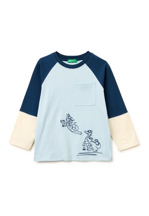 Camisa de manga larga para niños con mangas azul marino y crema, cuerpo azul claro, bolsillo en el pecho e ilustraciones juguetonas de dragones en el frente.