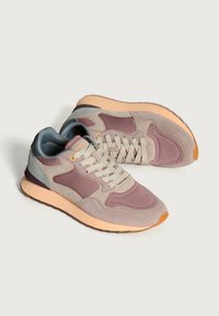 Zapatillas con una mezcla de tonos lavanda, gris y melocotón. Materiales de ante y malla, punta redondeada, lengüeta acolchada y suela de goma texturizada.