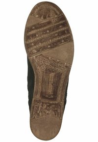 Suela de zapato de goma negra con un diseño de dibujo, nombre de la marca en relieve y texturas por el uso, con un borde elevado y suave y una punta redondeada.