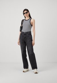 Black high-waisted jeans, striped black and white sleeveless top, white sneakers, and black sunglasses. Simple design, smooth texture.
