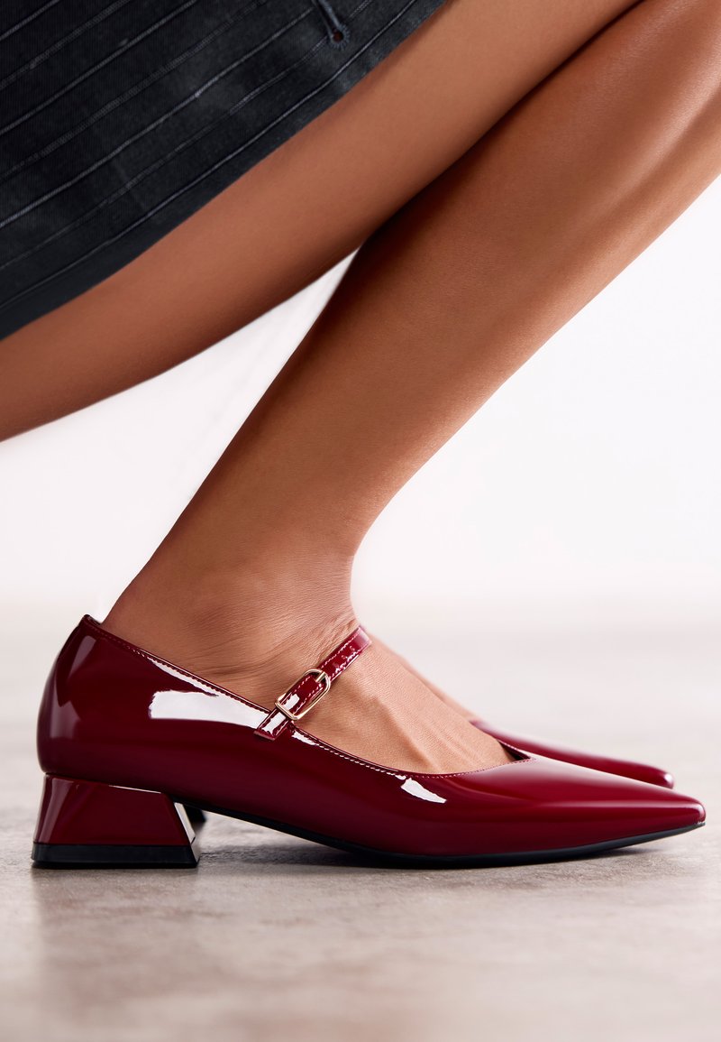 Scarpe Mary Jane in pelle laccata borgogna con punta affilata, cinturino alla caviglia regolabile e design del tacco a blocco in contrasto.