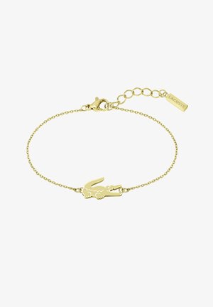 Bracciale dorato con un charm a forma di logo di coccodrillo, collegato tramite una delicata catena e un gancio, dotato di una catena di estensione con un'etichetta del logo.