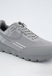 Chaussure de sport grise avec une partie supérieure en maille texturée, semelle en caoutchouc et lacets plats. Comprend des détails à motifs subtils et des coutures renforcées.