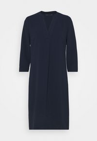 Marinblå klänning med V-ringning och trekvartsärmar, tillverkad av ett slätt tyg; har minimalistisk design och rak silhuett.