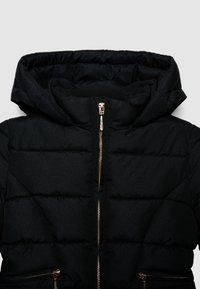 Schwarze gepolsterte Jacke mit Kapuze, ausgestattet mit einem Reißverschluss vorne und goldenen Hardware-Details. Die horizontale Steppung verleiht dem Stoff Struktur.