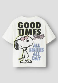Hvit bomull t-skjorte med en svart kontur av Snoopy som har på seg solbriller formet som hjerter. Teksten inkluderer "GOOD TIMES", "Snoopy" og "ALL SMILES ALL DAY" i sterke farger.