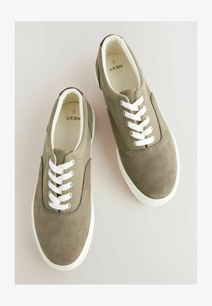 Pruun nubukist ja kangast tossud valgete paeltega, ümar varvas, kummist tallad ja pehme sisemine vooder. Brändi logo nähtav seest.