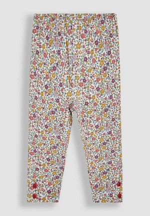 Mädchen-Leggings mit elastischem Bund, dichtem, mehrfarbigem Blumenmuster und zwei roten Knöpfen nahe jedem Knöchel auf weißem Hintergrund.