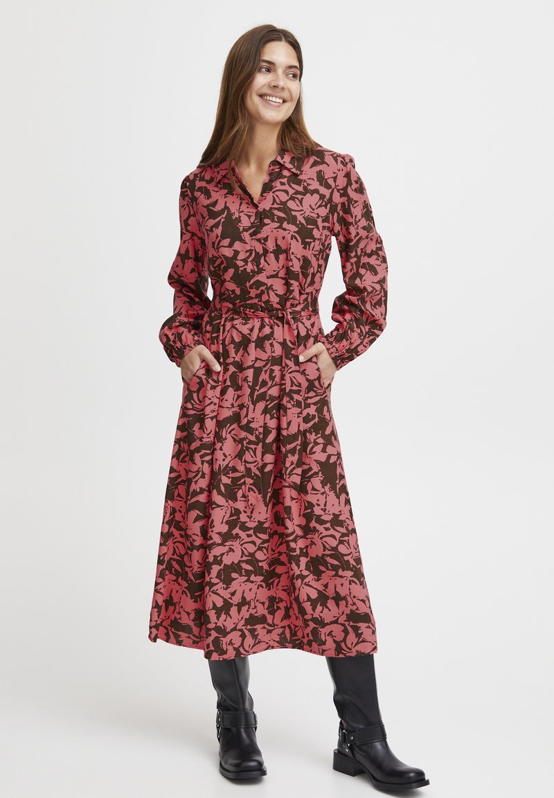 Rochie midi cu mânecă lungă, având un model floral roz pe un fundal maroniu, cu guler, cordon de prindere și buzunare laterale.