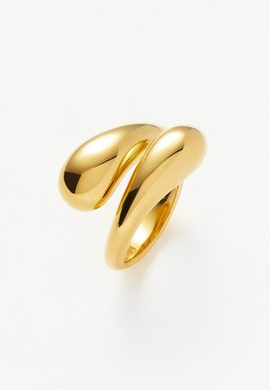 Anillo dorado brillante con un diseño moderno y abstracto, que presenta dos extremos lisos y redondeados que se curvan y entrelazan entre sí.