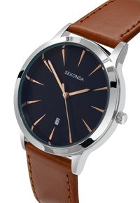 Montre en acier inoxydable argenté avec un cadran bleu foncé, aiguilles en rose gold, bracelet en cuir marron et fonction d'affichage de la date.